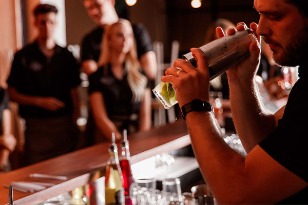 The Montague Hotel bar tender making cocktail in front of colleagues